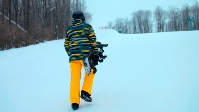 滑雪者穿着滑雪服和滑雪板爬山。专业的滑雪者正沿着赛道行走，手里拿着滑雪板。美丽的冬季风景。