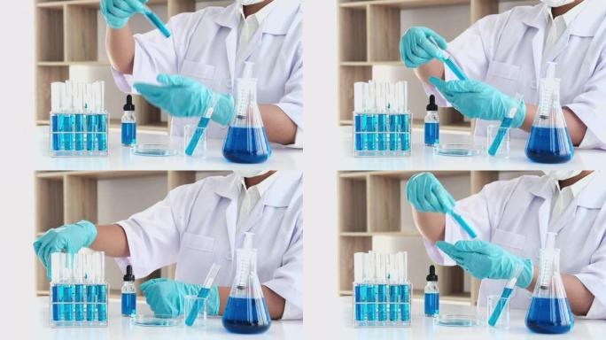 实验室工作的科学家或医学人员的4k视频录像，用于在临床实验室工作的玻璃设备上混合滴落彩色液体试剂的研