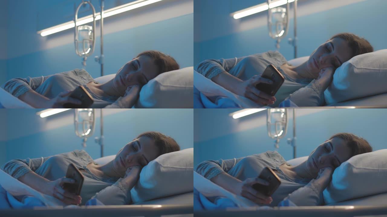 年轻的病人躺在医院的床上，使用她的智能手机
