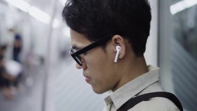 晚上戴着耳机听音乐的自由职业者在子路上用智能手机听音乐