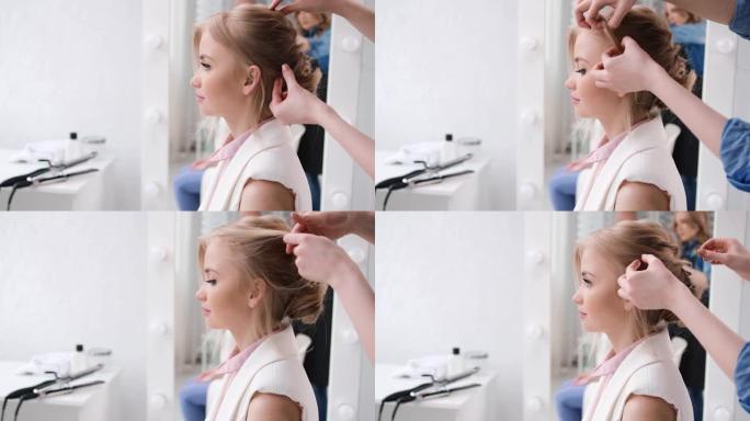 女模特坐在白色美容院内部创造发型。用4K红色相机拍摄