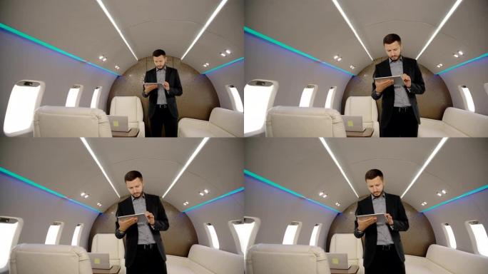 年轻自信的首席银行家董事商人使用平板电脑，沿着飞机内部行走