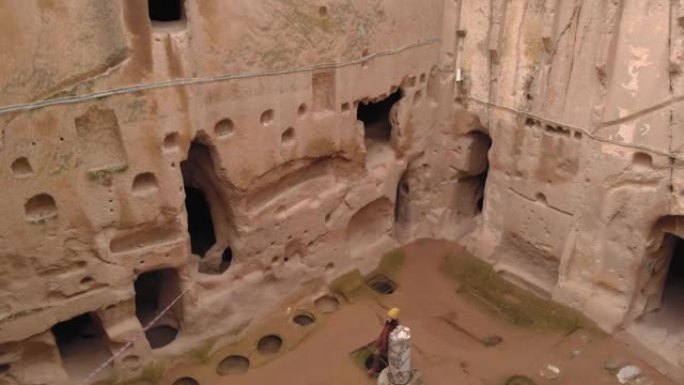 女人独自在卡帕多西亚的古穆斯勒洞穴修道院行走