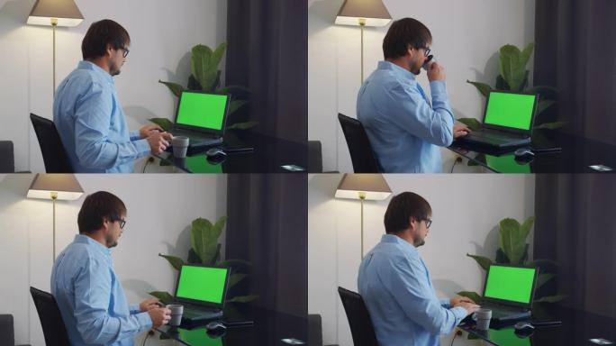 在家中坐在沙发上的男人在绿色模拟屏幕笔记本电脑上工作