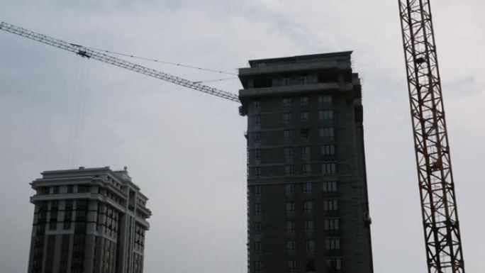 带起重机的摩天大楼的施工过程。正在建设中的高层住宅综合体。绿区公寓楼建设。正在建设中的现代住宅综合体