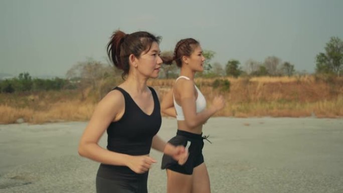 慢动作，在岩山越野跑的伙伴，运动员适合两名女性运动跑步者在美丽的大自然中专业户外艰难而富有挑战性的健