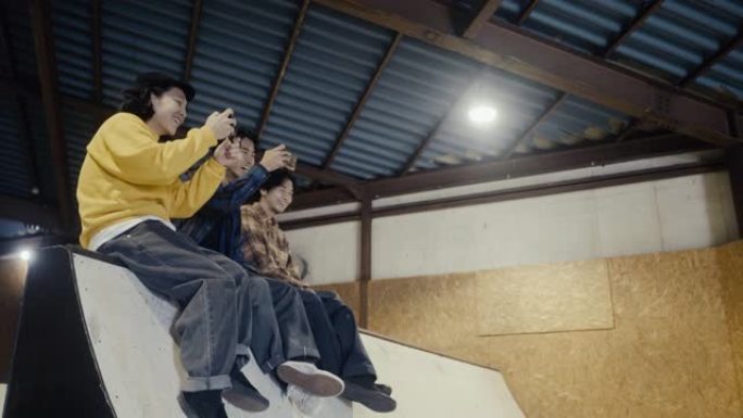 日本男孩在坡道上拍摄他们的朋友滑板 (慢动作)