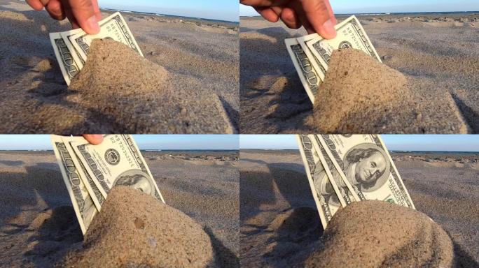 一个女孩从沙子上拿出300美元的钞票