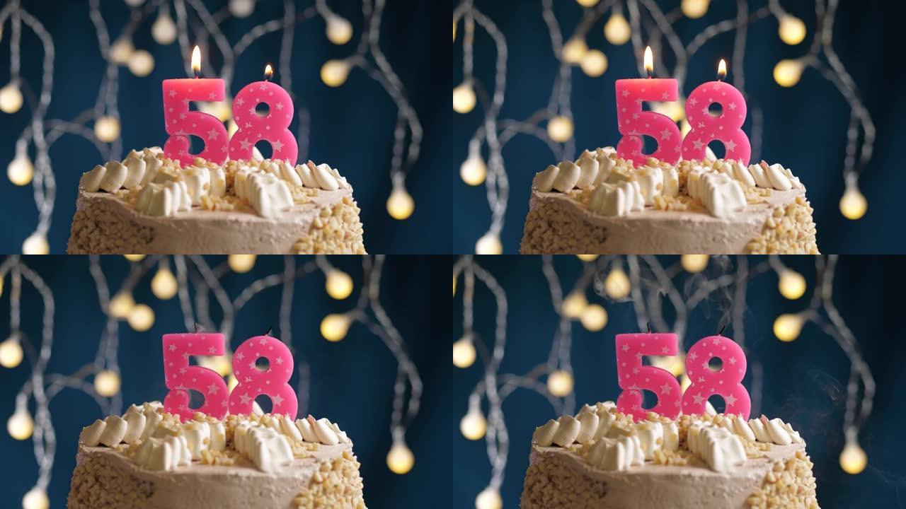 蓝色背景上有58号粉色蜡烛的生日蛋糕。蜡烛吹灭了。慢动作和特写视图