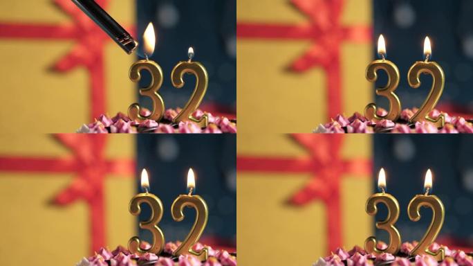 生日蛋糕编号32点灯燃烧的金色蜡烛，蓝色背景礼物黄色盒子用红丝带绑起来。特写和慢动作