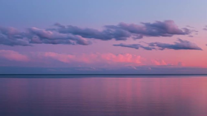 湖边的粉红色和紫色棉花糖日落。美丽的自然海滩背景。4k延时