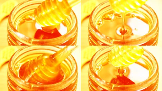 蜂蜜从玻璃碗中的蜂蜜北斗七星滴落。特写。健康有机浓蜂蜜从玻璃蜜勺蘸，特写。