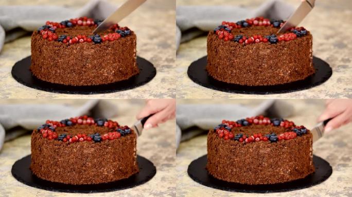女人用刀切俄罗斯巧克力蛋糕拿破仑。浆果酥皮巧克力拿破仑蛋糕。