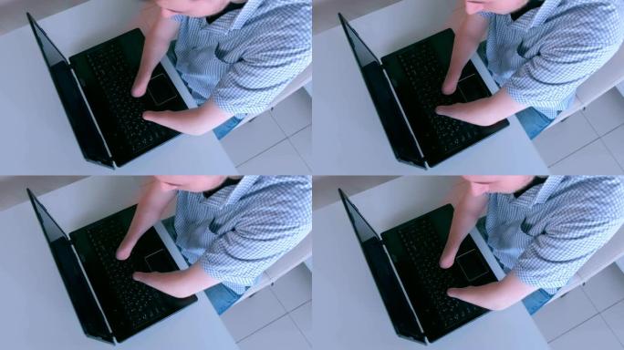 残疾人残肢打字在笔记本电脑上，特写俯视图。