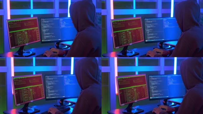 特写镜头的黑客穿着黑暗的工作在电脑上