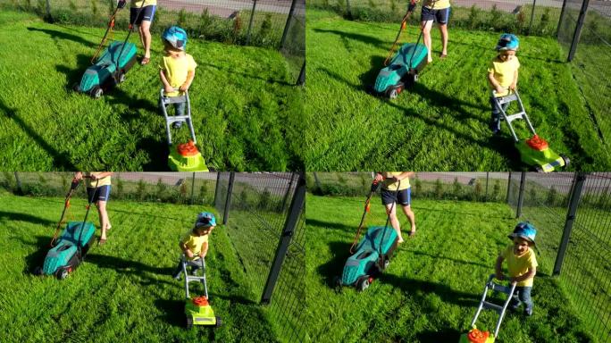 快乐活跃的蹒跚学步的男孩，在父亲面前拿着玩具割草机。万向节运动