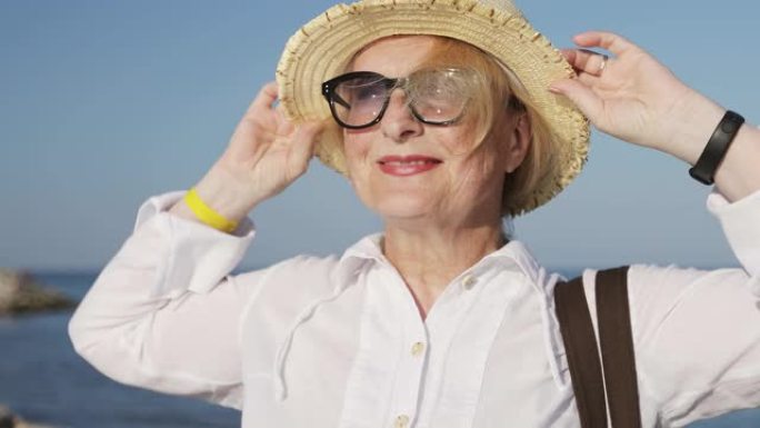 海滩上一个戴着帽子的深深的皱纹的老妇人的肖像。