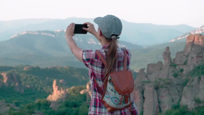 回归自然。视频记录。自拍时间。单人旅行者在美丽的全景前，从高处俯瞰美丽的红色岩层。一个快乐的年轻女子
