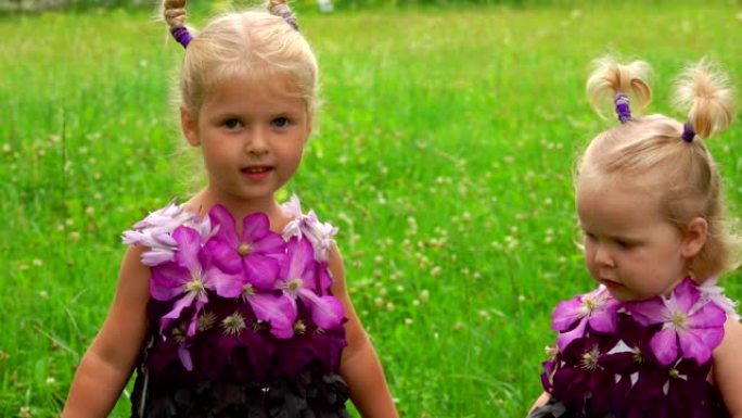 两个穿着紫色幻想连衣裙的小姐妹正在看镜头
