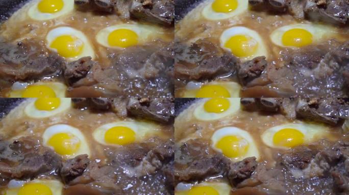 鸡蛋和猪肉在锅里用脂肪油炸。贫穷和不健康饮食的概念。