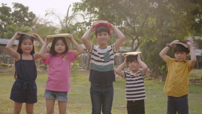 一群小孩子的团队合作教育与户外的书本学习知识，小学的多样化孩子，大学生堆叠手的概念