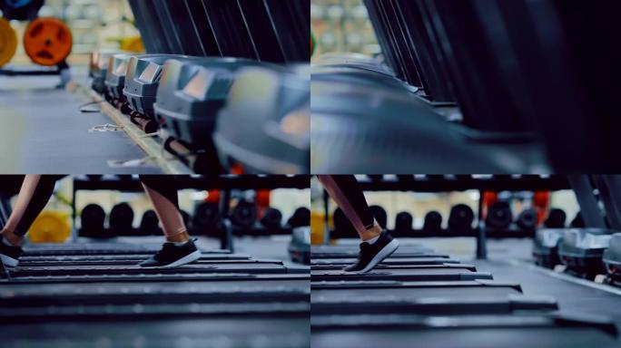 健身房里的健身器材。女孩在跑步机上行走，双腿穿着运动鞋。摄像机的侧面跨度，底视图。
