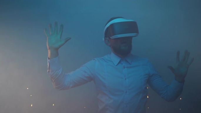 人迷失在增强现实中，年轻的工程师测试虚拟现实耳机，带霓虹灯的蓝色照明房间营造虚拟现实氛围。电子技术、