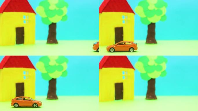 橙色汽车经过黄房子和树-停止运动