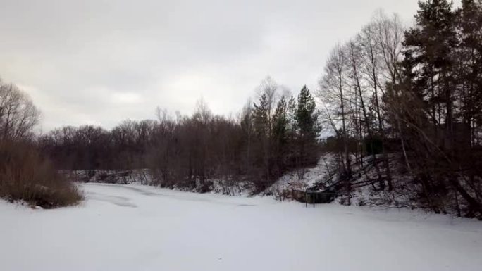 无人机在森林冻结的河床上的低空飞行