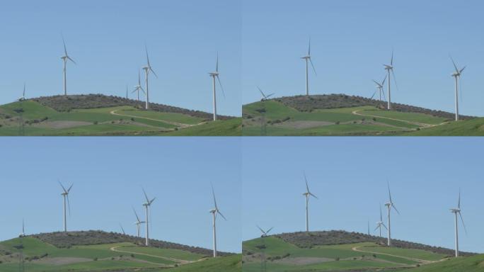 蓝天下的风力涡轮机在野外移动叶片中的景观