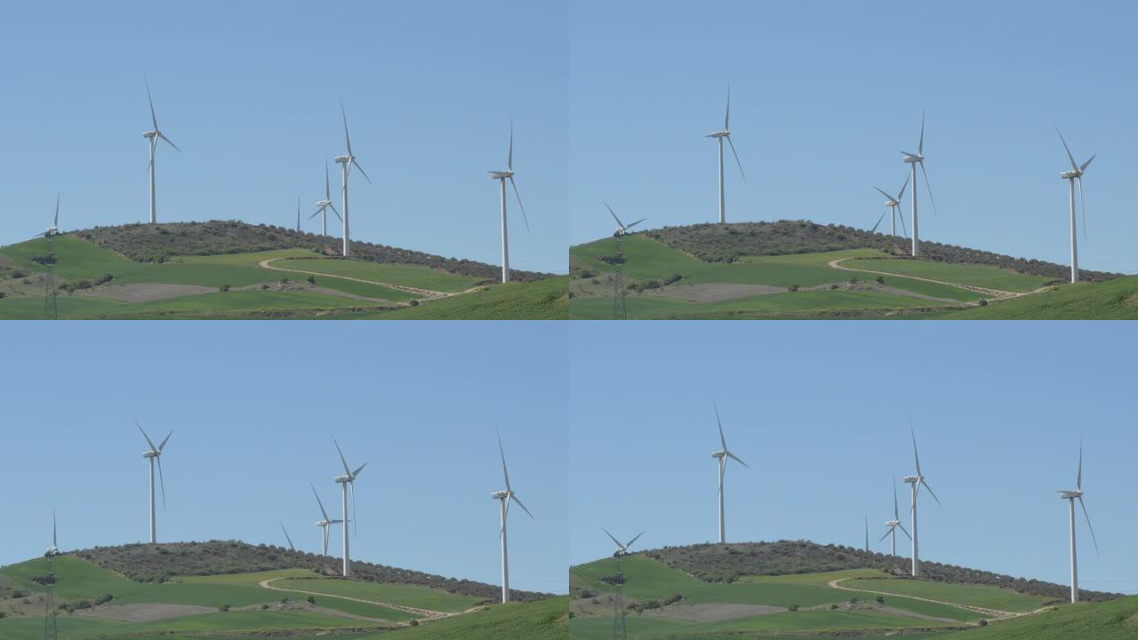 蓝天下的风力涡轮机在野外移动叶片中的景观