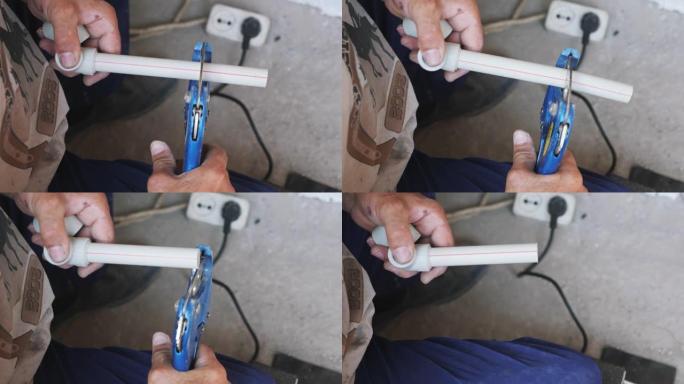 剪刀切割塑料管特写。管道工用剪管剪刀握管。