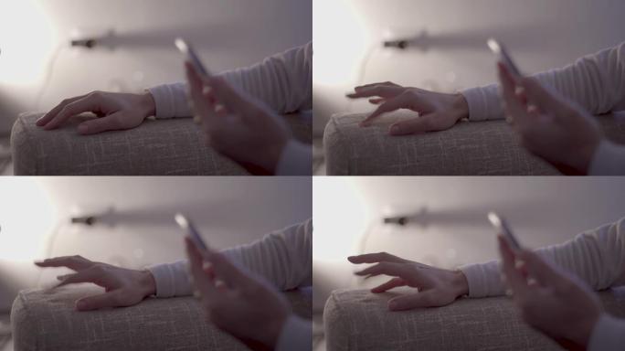 现代生活的压力: 女人的手的特写镜头，手指在沙发上紧张地敲击，在柔和的灯光，无等级的现代氛围中等待智