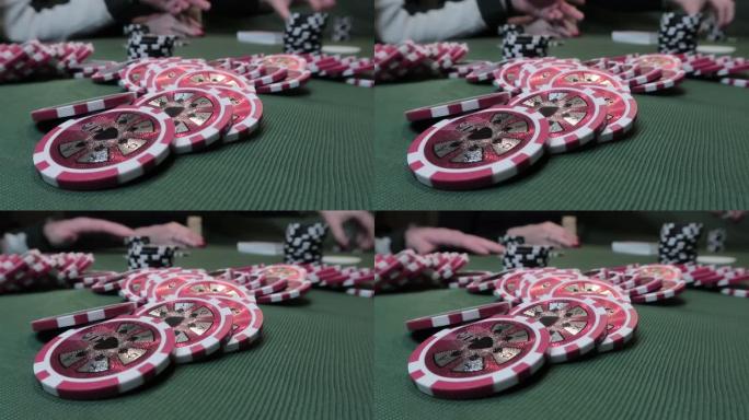 扑克筹码的特写在绿色的布上玩扑克的人的背景