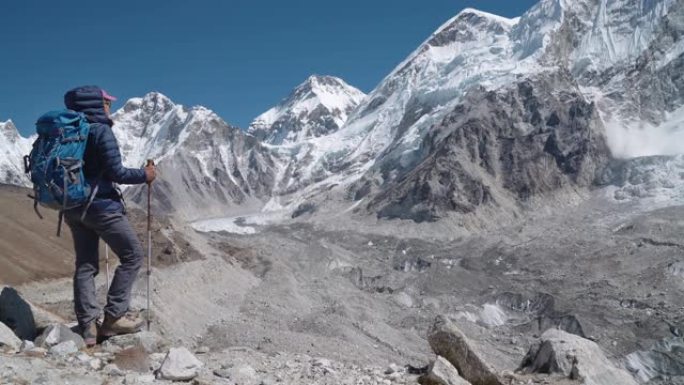 4k年轻徒步旅行者背包客女性在徒步旅行中刹车，享受昆布冰川。尼泊尔戈拉克谢普附近的高海拔珠穆朗玛峰大