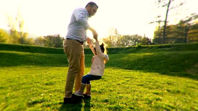 年轻的父亲和他的女儿在公园跳舞
