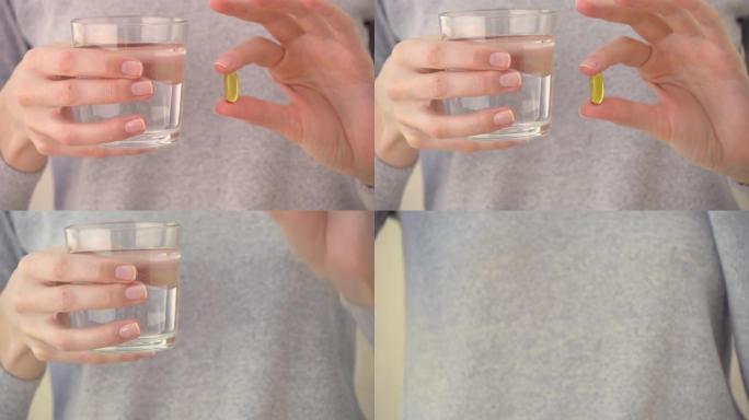 女孩拿着一杯水和药片在手臂的长度，在胸部水平。然后他喝酒。在镜头前演示。