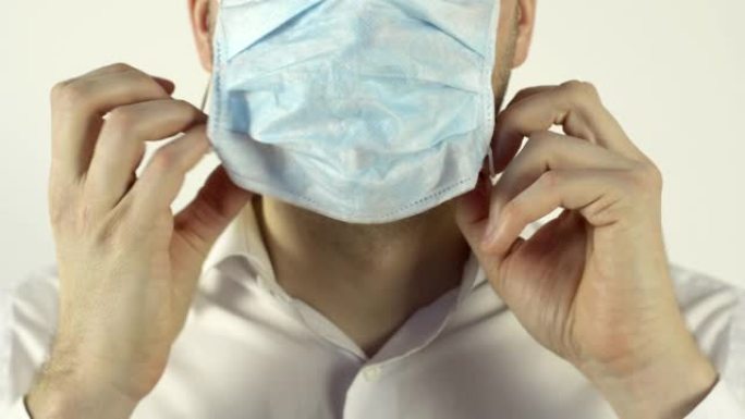 一名男子在他的脸上贴着病毒的防护医用口罩。防御冠状病毒、大流行、COVID-2019的概念