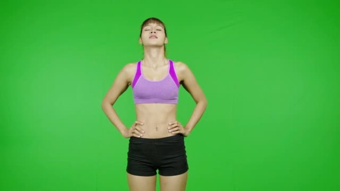 颈部暖身、绿屏、运动、伸展。适合年轻的亚洲运动妇女在紫色的布料做热身运动在镜头前。