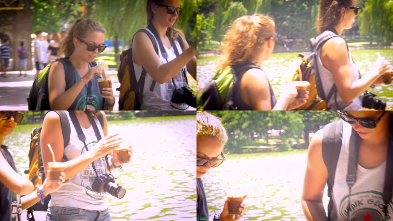 手持拍摄的两名年轻女性行走和喝冰咖啡度假。