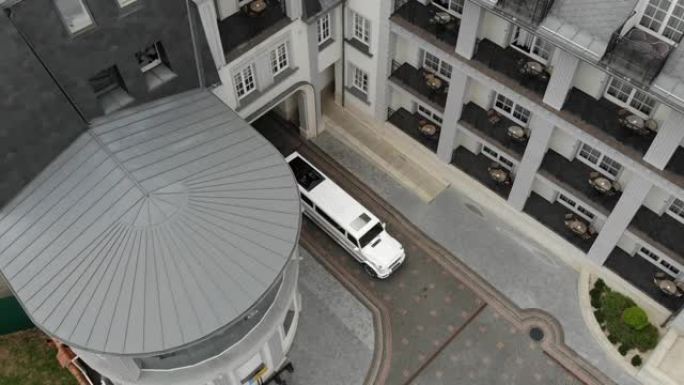 在酒店庭院中乘坐的鸟瞰图白色豪华轿车