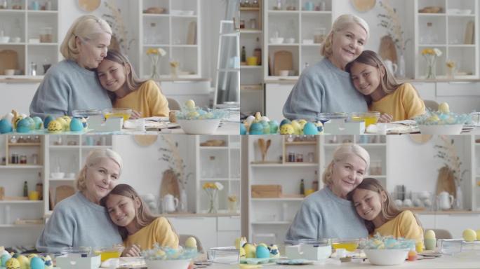 可爱的女孩和奶奶一起在餐桌上摆复活节彩蛋