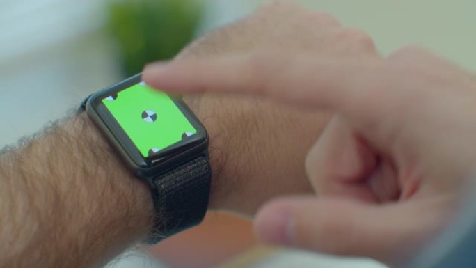 人手使用智能手表与绿屏chromakey内容触摸显示通信特写。