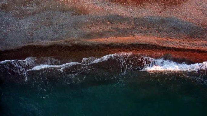 鸟瞰图美丽的海浪缓缓散布在海滩上。美丽的海浪在日落的黄金时刻。无人机摄像机观看茴香