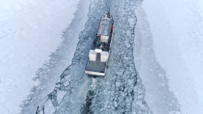 无人驾驶飞机在冰冻的湖面上追赶一艘小船破冰船