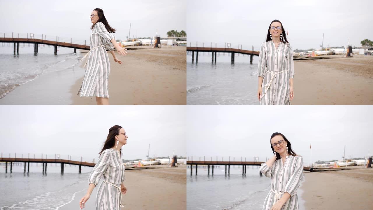 快乐的女人光着脚在海滩上玩在一个长裙子。