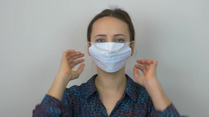 女人的肖像正在戴上医用口罩，以预防和保护病毒感染。年轻女性戴上保护面具，冠状病毒大流行的危险2019