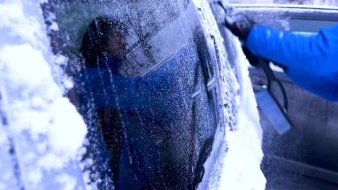 男子用手清洁白雪上的车窗