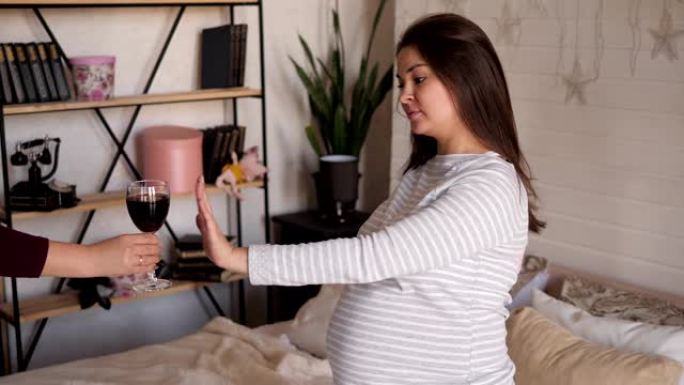 孕妇拒绝喝酒在家的卧室床上。