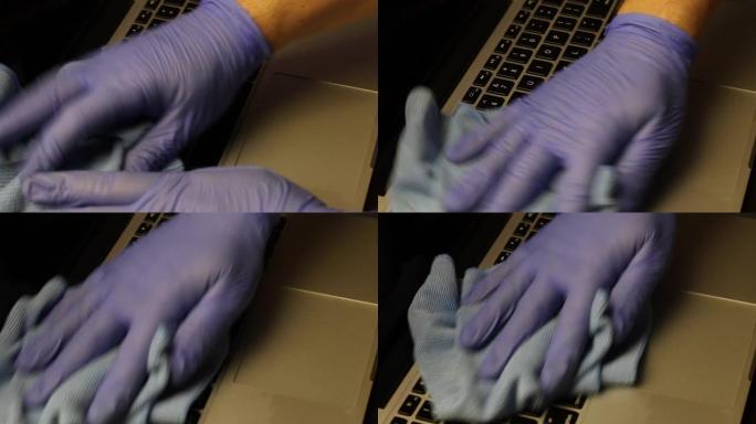 一个戴着橡胶手套的男人正在清洁他的笔记本电脑。他用餐巾纸擦拭笔记本电脑键盘。保护工作设备免受病毒感染
